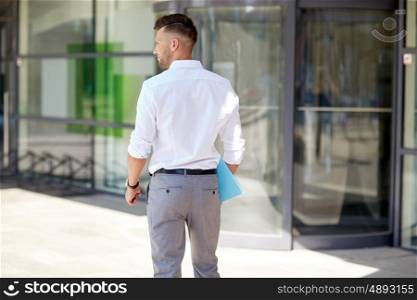 business and people concept - young man with folder on city street. young man with folder on city street