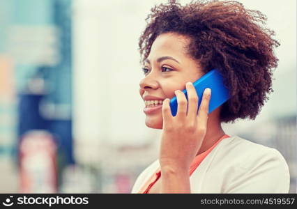 business and people concept - young smiling african american businesswoman in city. happy young african american businesswoman in city