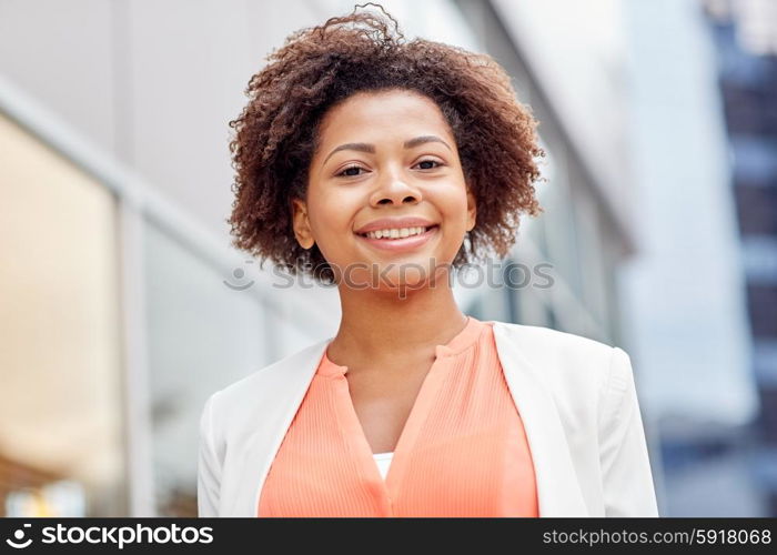 business and people concept - young smiling african american businesswoman in city. happy young african american businesswoman in city