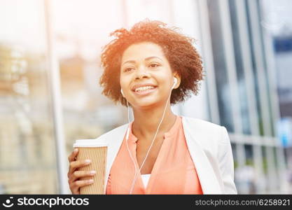 business and people concept - young smiling african american businesswoman with coffee cup in city. happy african businesswoman with coffee in city