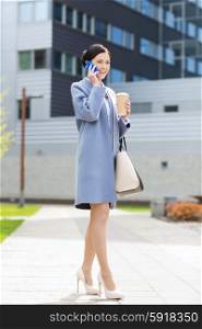 business and people concept - young smiling businesswoman calling on smartphone over office building. happy businesswoman calling on smartphone in city