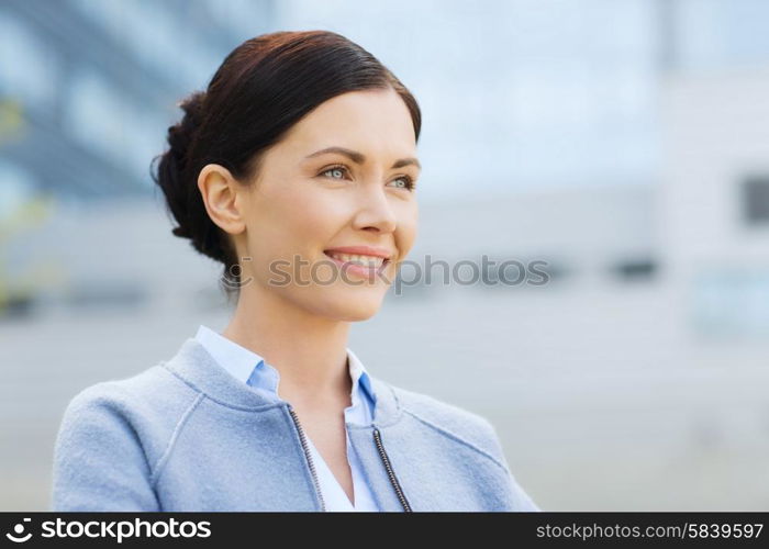 business and people concept - young smiling businesswoman over office building. young smiling businesswoman over office building