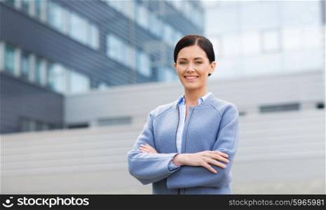 business and people concept - young smiling businesswoman over office building. young smiling businesswoman over office building