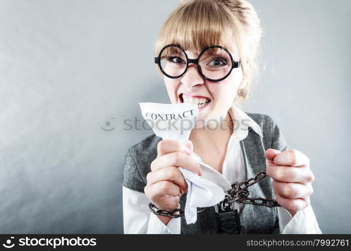 Business and stress concept. Furious businesswoman in glasses with chained hands holding contract grunge background unusual angle view