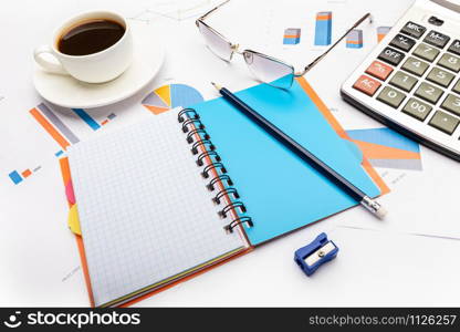 Business and study concept with open notepad, calculator, pencil, coffee and documents.