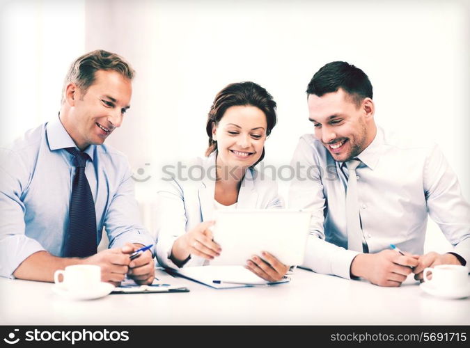 business and technology concept - business team looking at tablet pc in office