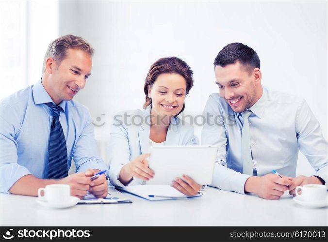 business and technology concept - business team looking at tablet pc in office. business team looking at tablet pc in office