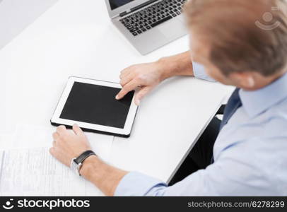 business and technology concept - businessman with tablet pc in office