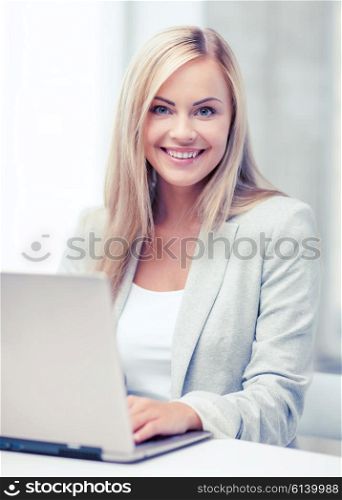 business and technology concept - businesswoman with laptop in office. businesswoman with laptop in office