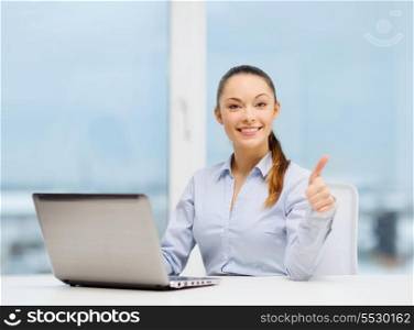 business and technology concept - businesswoman with laptop in office showing thumbs up