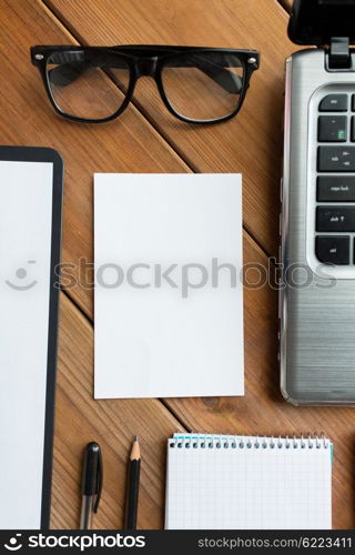 business and technology concept - close up of blank paper and office supplies on wooden table. close up of blank paper and office supplies