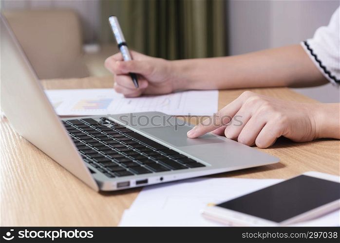 Business and technology concept. Closeup of businesswoman working with laptop and mobile in office. Wireless technology and internet.