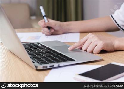 Business and technology concept. Closeup of businesswoman working with laptop and mobile in office. Wireless technology and internet.