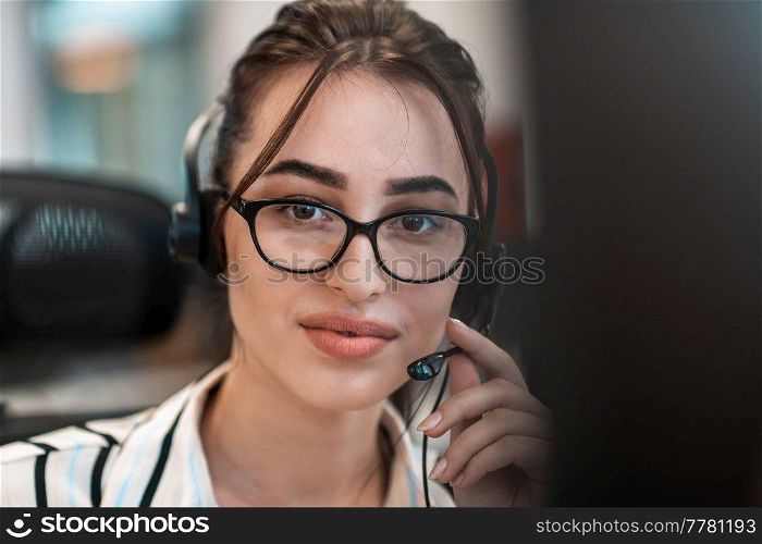 Business and technology concept - helpline female operator with headphones in a call center.Businesswoman with headsets working in a call center. High-quality photo. Business and technology concept - helpline female operator with headphones in call centre .Business woman with headsets working in a call center