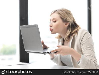 business and technology concept - picture of woman with laptop computer kissing the screen
