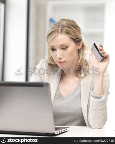 business and technology concept - serious woman with laptop computer and credit card