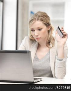 business and technology concept - serious woman with laptop computer and credit card