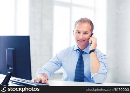 business and technology concept - smiling businessman with smartphone in office. smiling businessman with smartphone in office