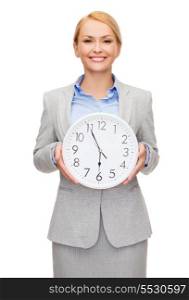 business and time concept - attractive businesswoman with wall clock