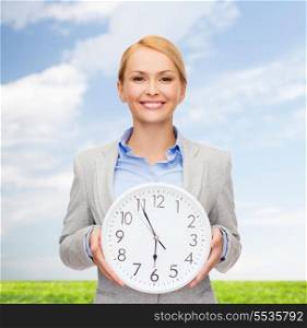 business and time concept - attractive businesswoman with wall clock