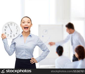 business and time concept - attractive businesswoman with wall clock