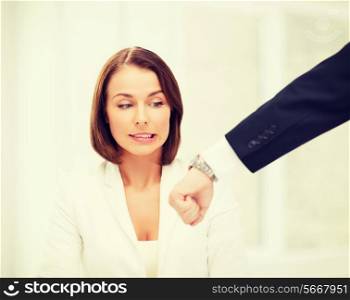 business and time management concept - boss showing watch to stressed businesswoman