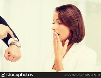 business and time management concept - boss showing watch to stressed businesswoman