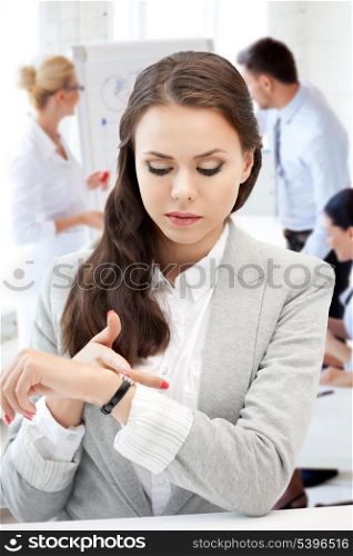 business and time management concept - businesswoman looking at alarm clock