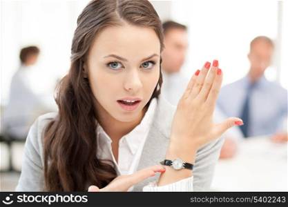 business and time management concept - businesswoman pointing at her watch