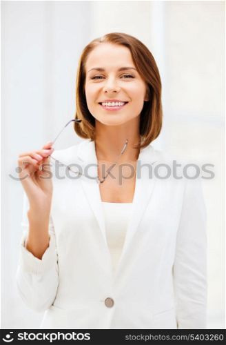 business and vision correction concept - businesswoman with eyeglasses in office
