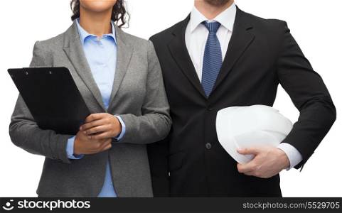 business, architecture and development concept - businesswoman and businessman with clipboard and white helmet