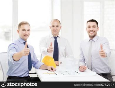 business, architecture and office concept - happy team of architects and designers in office showing thumbs up