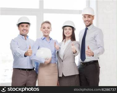 business, architecture and office concept - happy team of architects in office showing thumbs up