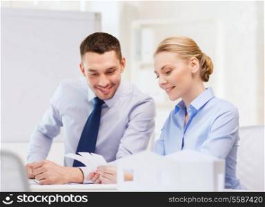 business, architecture and office concept - smiling businessman and businesswoman looking at color samples at office