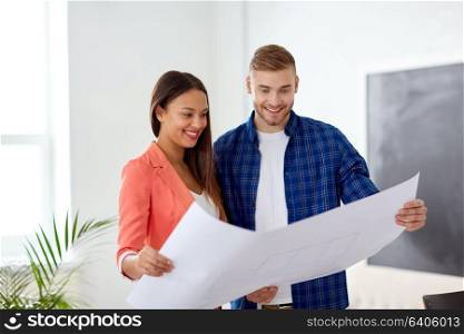 business, architecture and people concept - happy creative team or architects with blueprint working at office. creative team with blueprint working at office