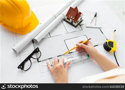 business, architecture, building, construction and people concept - close up of architect hands with ruler and pencil measuring living house blueprint
