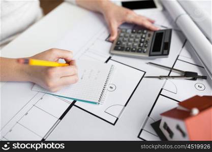 business, architecture, building, construction and people concept - close up of architect hand with blueprint counting on calculator