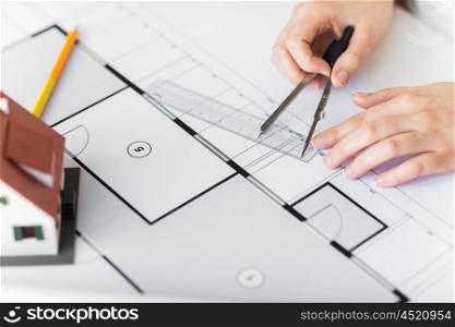 business, architecture, building, construction and people concept - close up of architect hands with compass and ruler measuring living house blueprint