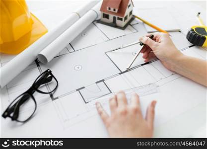 business, architecture, building, construction and people concept - close up of architect hands with compass measuring living house blueprint