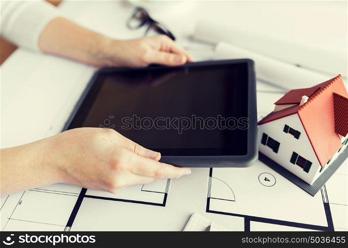 business, architecture, building, construction and people concept - close up of architect hand with living house blueprint and tablet pc computer. close up of hand with blueprint and tablet pc