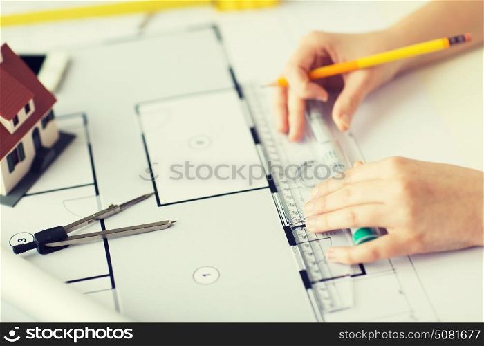 business, architecture, building, construction and people concept - close up of architect hands with ruler and pencil measuring living house blueprint. close up of hands with compass measuring blueprint