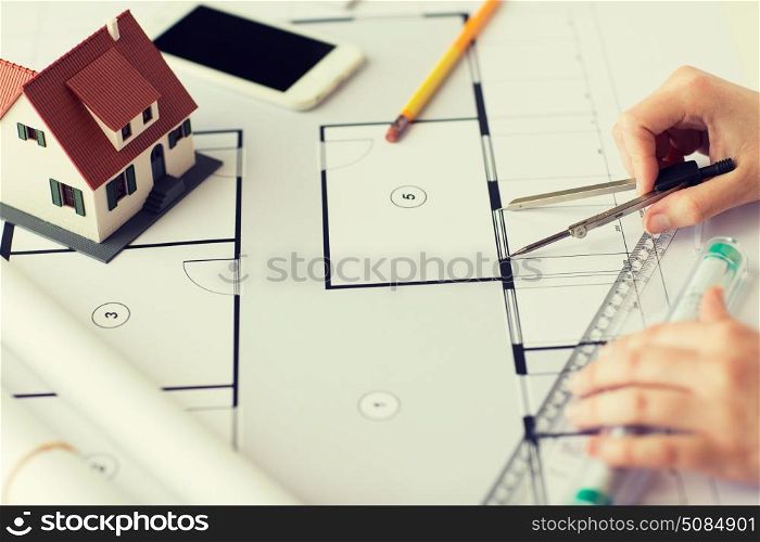 business, architecture, building, construction and people concept - close up of architect hands with compass and ruler measuring living house blueprint. close up of hands with compass measuring blueprint. close up of hands with compass measuring blueprint