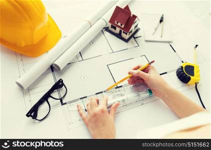 business, architecture, building, construction and people concept - close up of architect hands with ruler and pencil measuring living house blueprint. close up of hands with ruler measuring blueprint