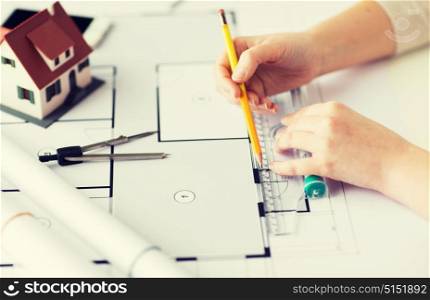 business, architecture, building, construction and people concept - close up of architect hands with ruler and pencil measuring living house blueprint. close up of hands with compass measuring blueprint