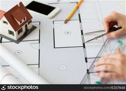 business, architecture, building, construction and people concept - close up of architect hands with compass and ruler measuring living house blueprint