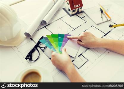 business, architecture, building, construction and people concept - close up of designer hands with color palette and blueprint. close up of hands with color palette and blueprint
