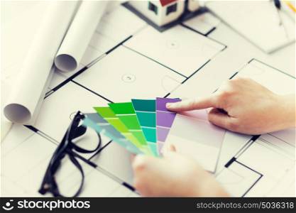 business, architecture, building, construction and people concept - close up of designer hands with color palette and blueprint. close up of hands with color palette and blueprint