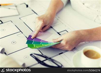 business, architecture, building, construction and people concept - close up of designer hands with color palette and blueprint. close up of hands with color palette and blueprint. close up of hands with color palette and blueprint