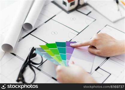 business, architecture, building, construction and people concept - close up of designer hands with color palette and blueprint