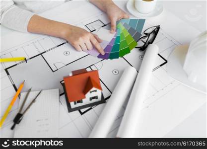 business, architecture, building, construction and people concept - close up of designer hands with color palette and blueprint